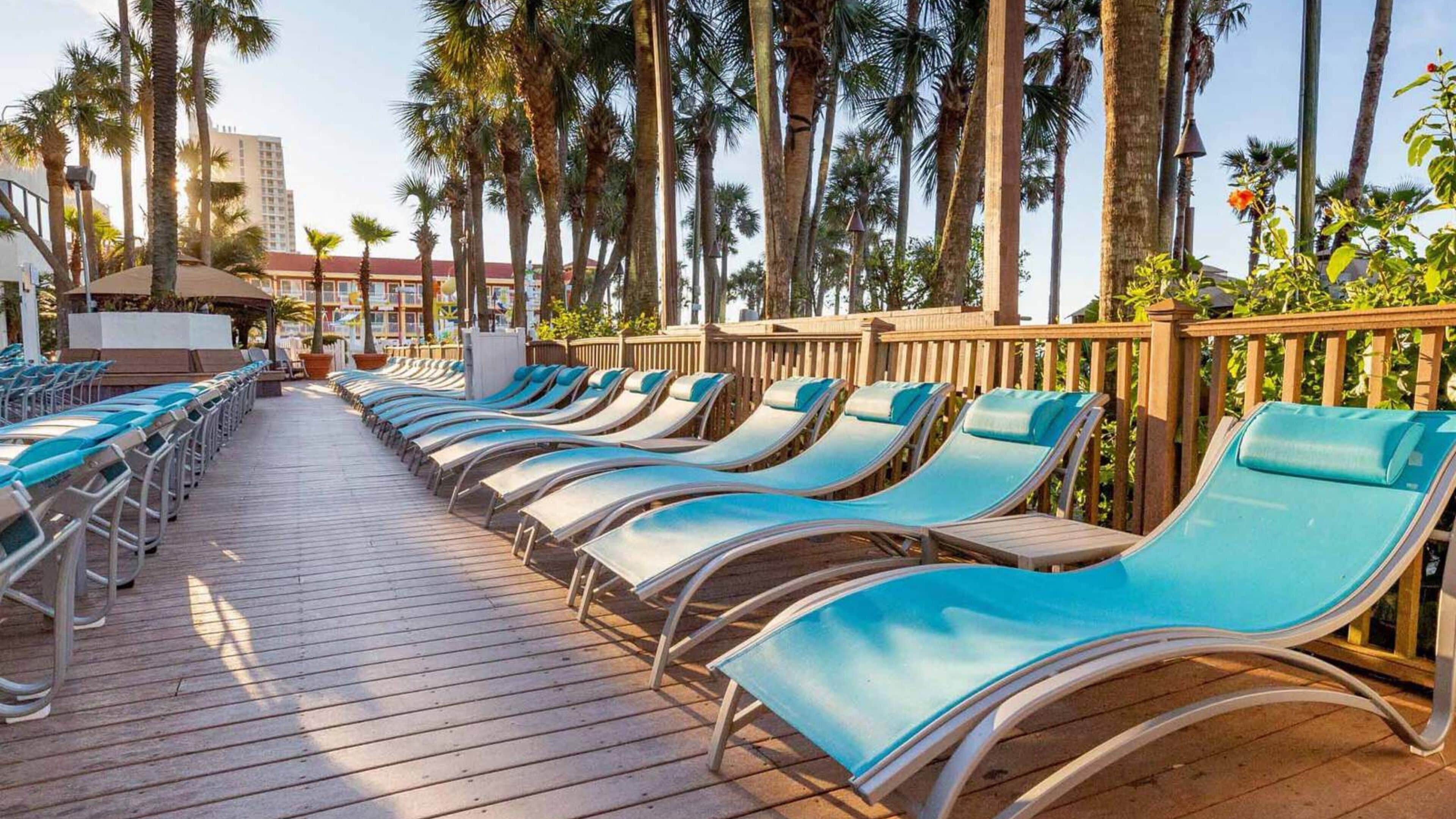 Une terrasse ensoleillée avec des chaises longues et une plateforme en bois.