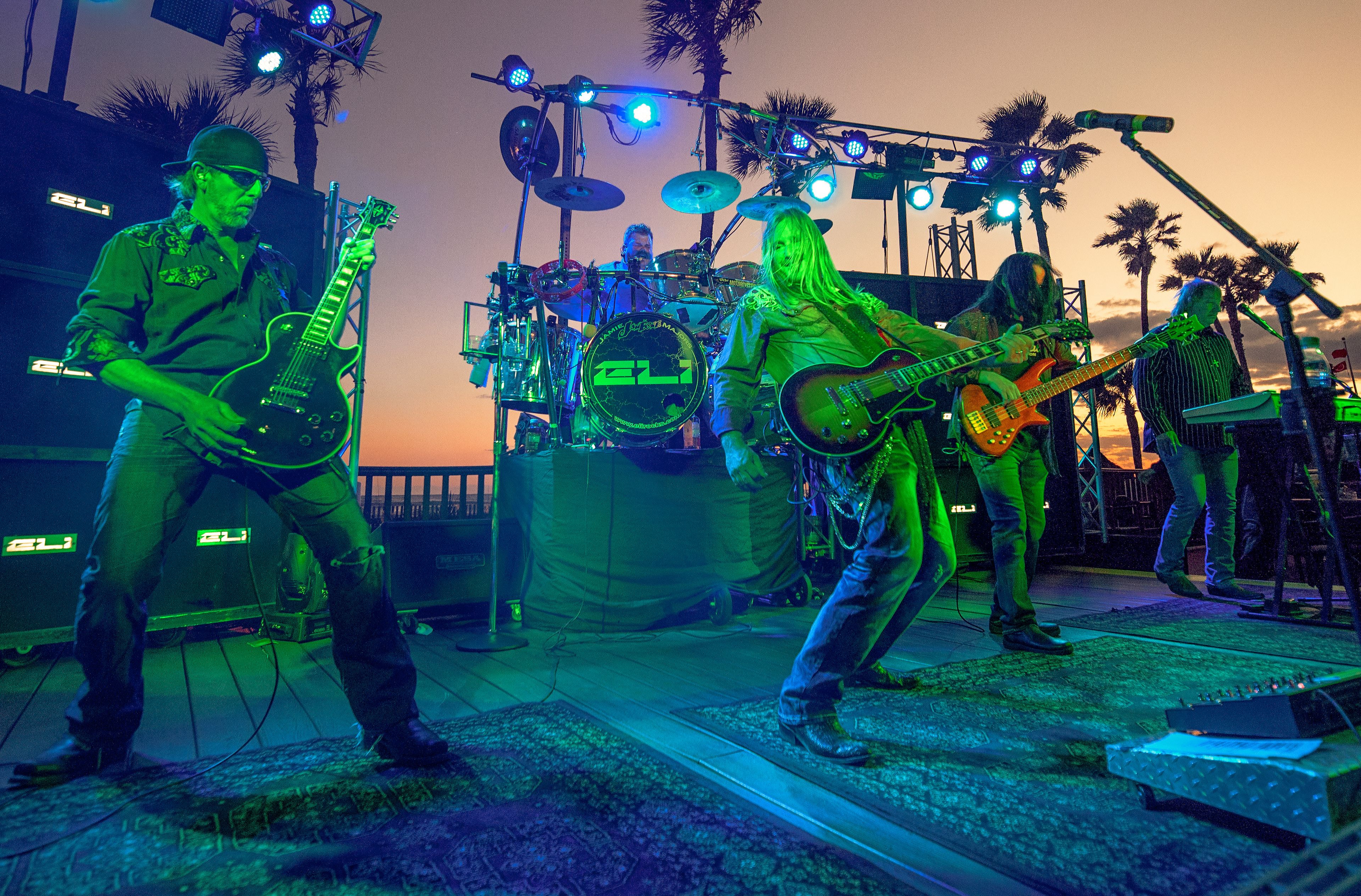 A band performing on a stage with musical instruments and a drum set.