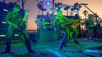 A band performing on a stage with musical instruments and a drum set.