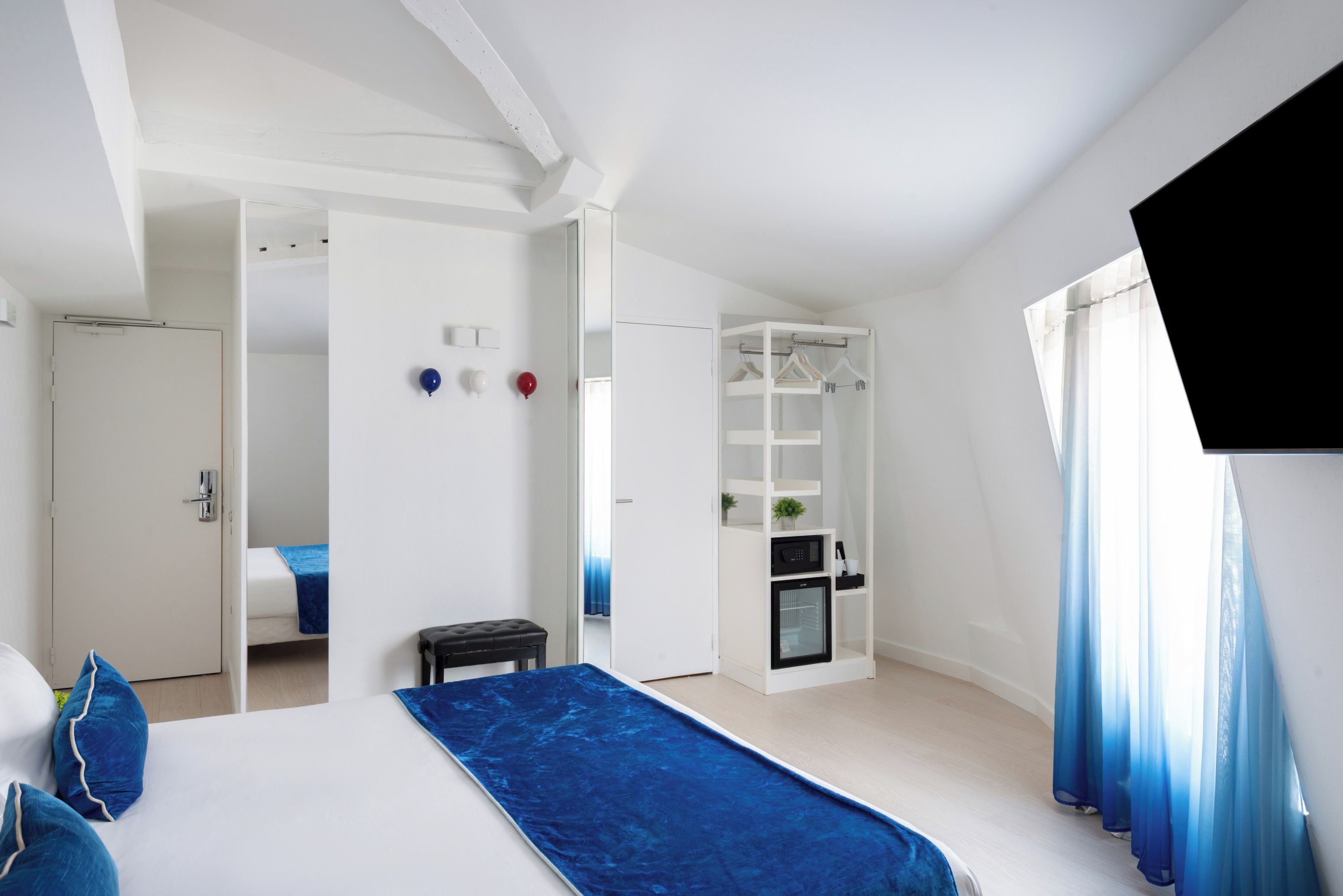 Un dormitorio moderno con una cama grande, un vestidor y una kitchenette.