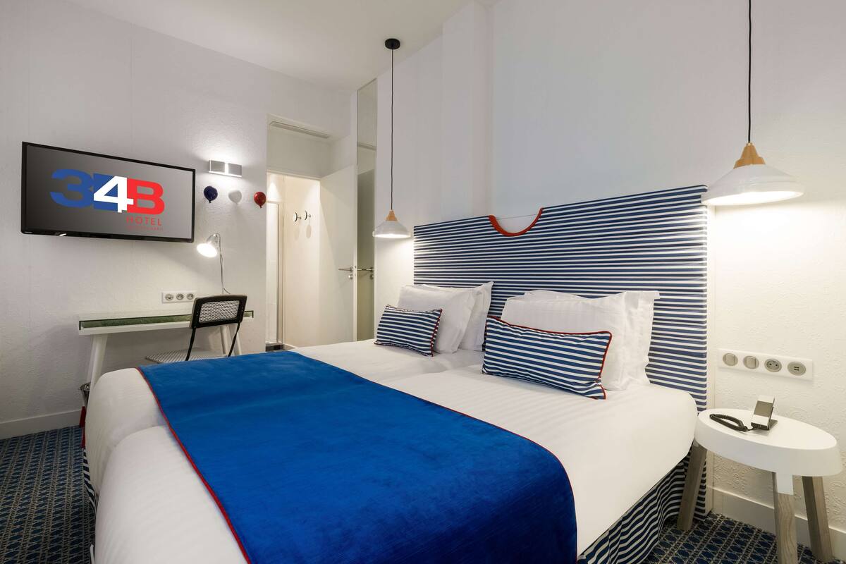 Une chambre d’hôtel comprenant un lit, un bureau, une chaise, une télévision et une table de chevet.