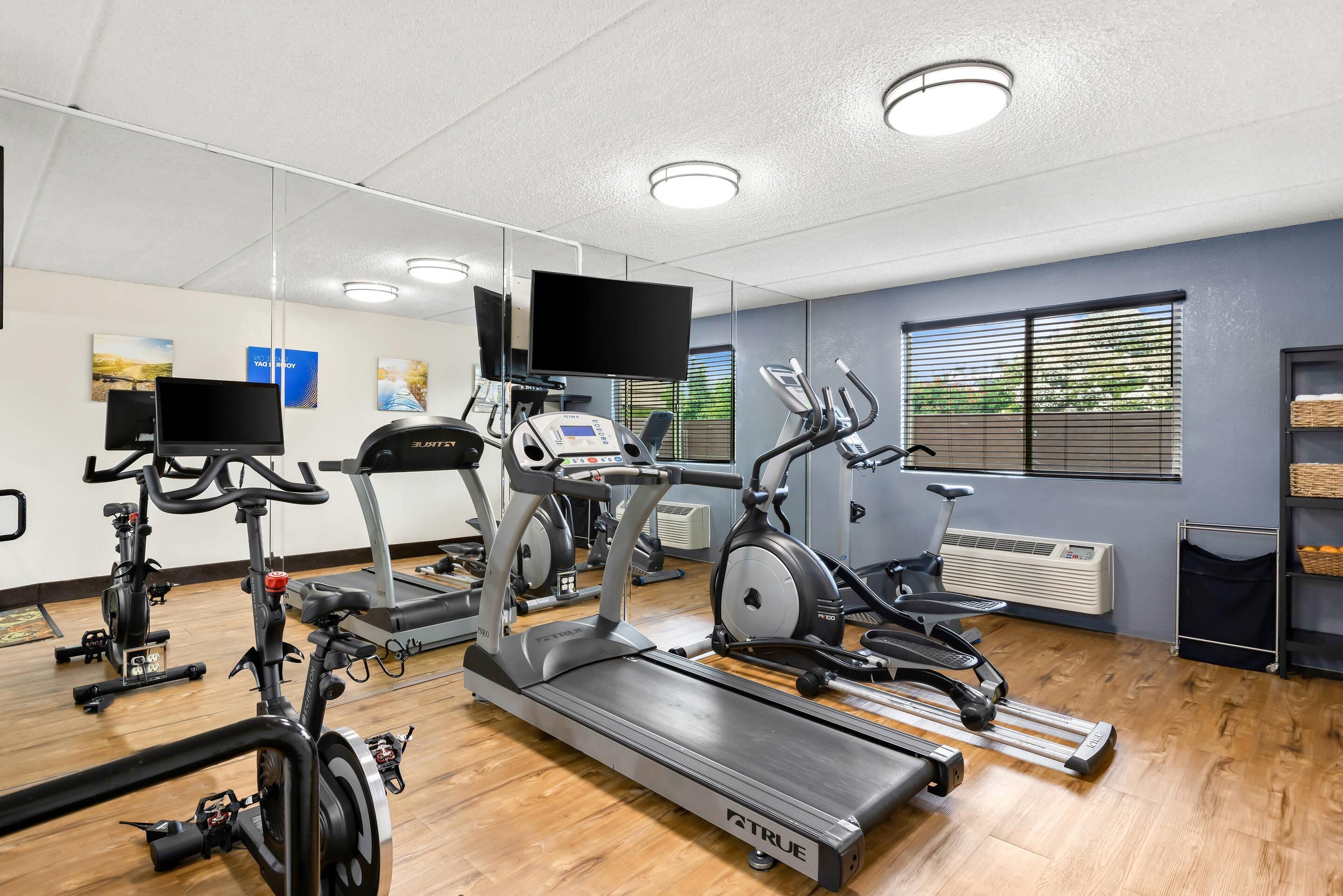 A gym with treadmills, stationary bikes, and elliptical machines.