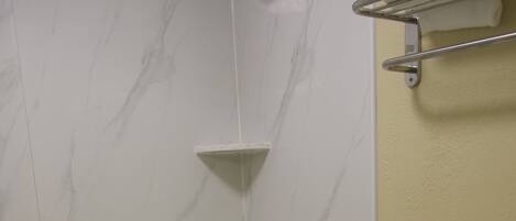 A bathroom with a bathtub, toilet, and a shower.