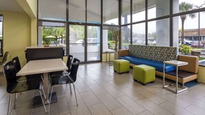 A modern indoor seating area with a table and chairs, a sofa, and a small side table.