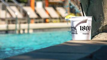 A poolside setting with a drink cup labeled '1800 Tequila' and a pool with clear blue water.