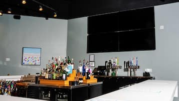 Zona de bar con varias botellas, una caja registradora y un ventanal grande.