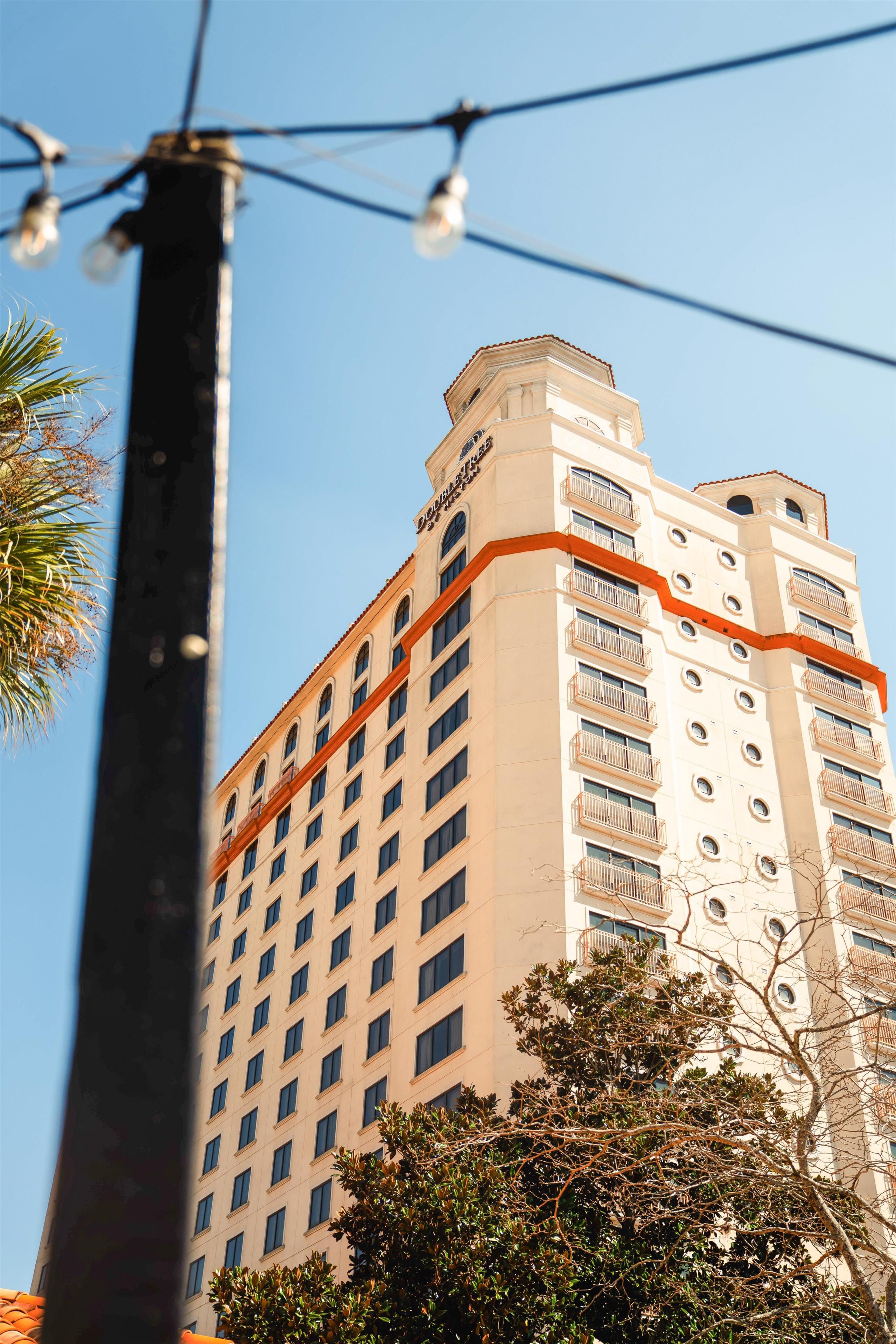 Un hotel con varios pisos, balcones y cielo despejado.