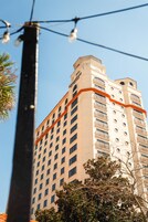 A hotel with multiple floors, balconies, and a clear sky.