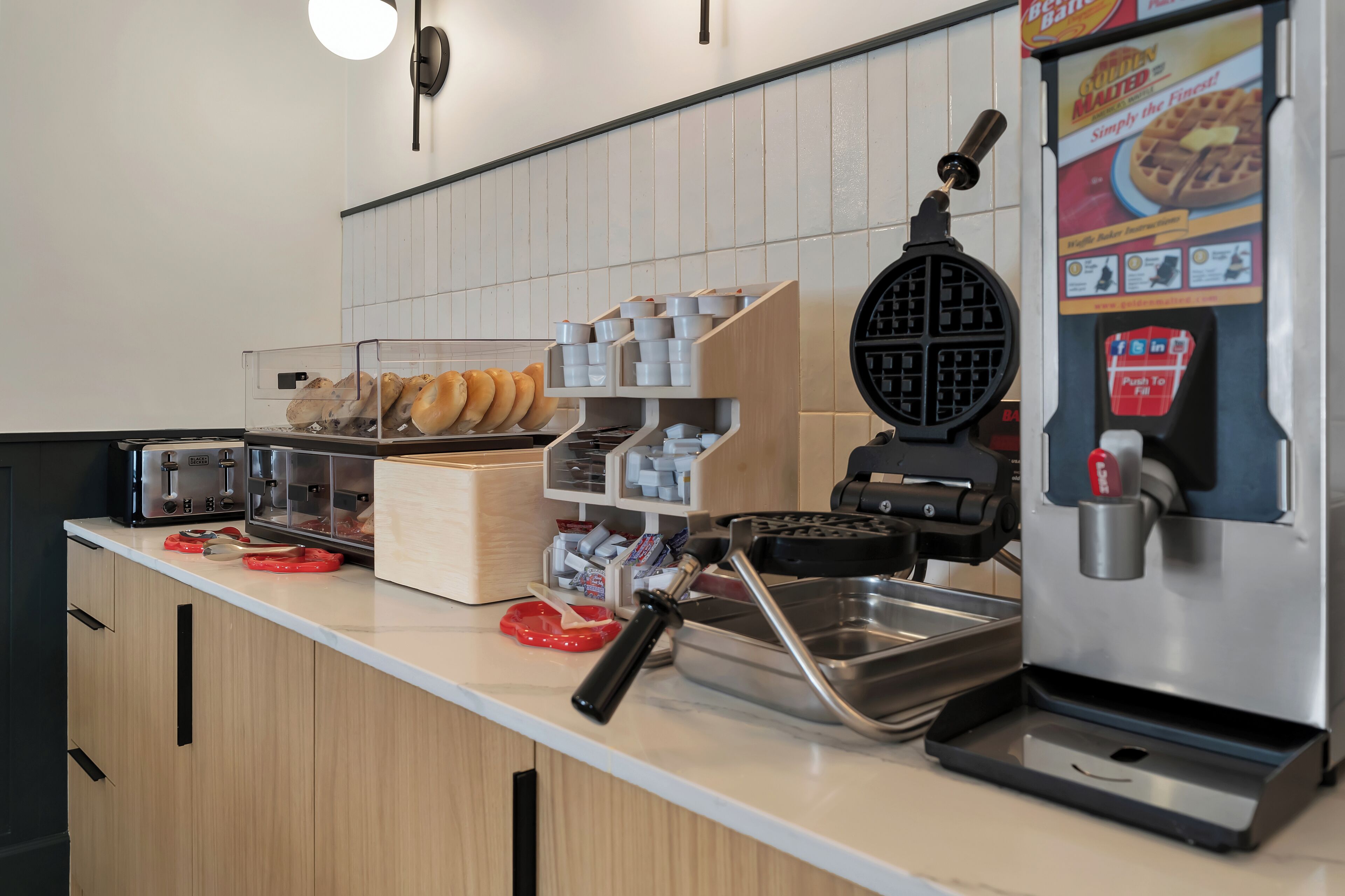 Eine Küchenarbeitsplatte mit einem Waffeleisen, einer Kaffeemaschine und einer Auswahl an Waffeln.