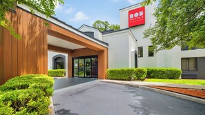 A modern hotel entrance with a wooden facade, glass doors, and a sign for 'BOB HOTELS'.