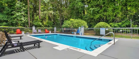 A rectangular outdoor pool with a metal ladder and a sign indicating a depth of 3 feet 9 inches.