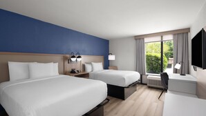 A hotel room with two beds, a desk, a TV, and a window with curtains. - La Quinta Inn & Suites by Wyndham Myrtle Beach (Myrtle Beach)