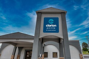 A hotel entrance with a sign reading "Clarion Pointe By Choice Hotels".