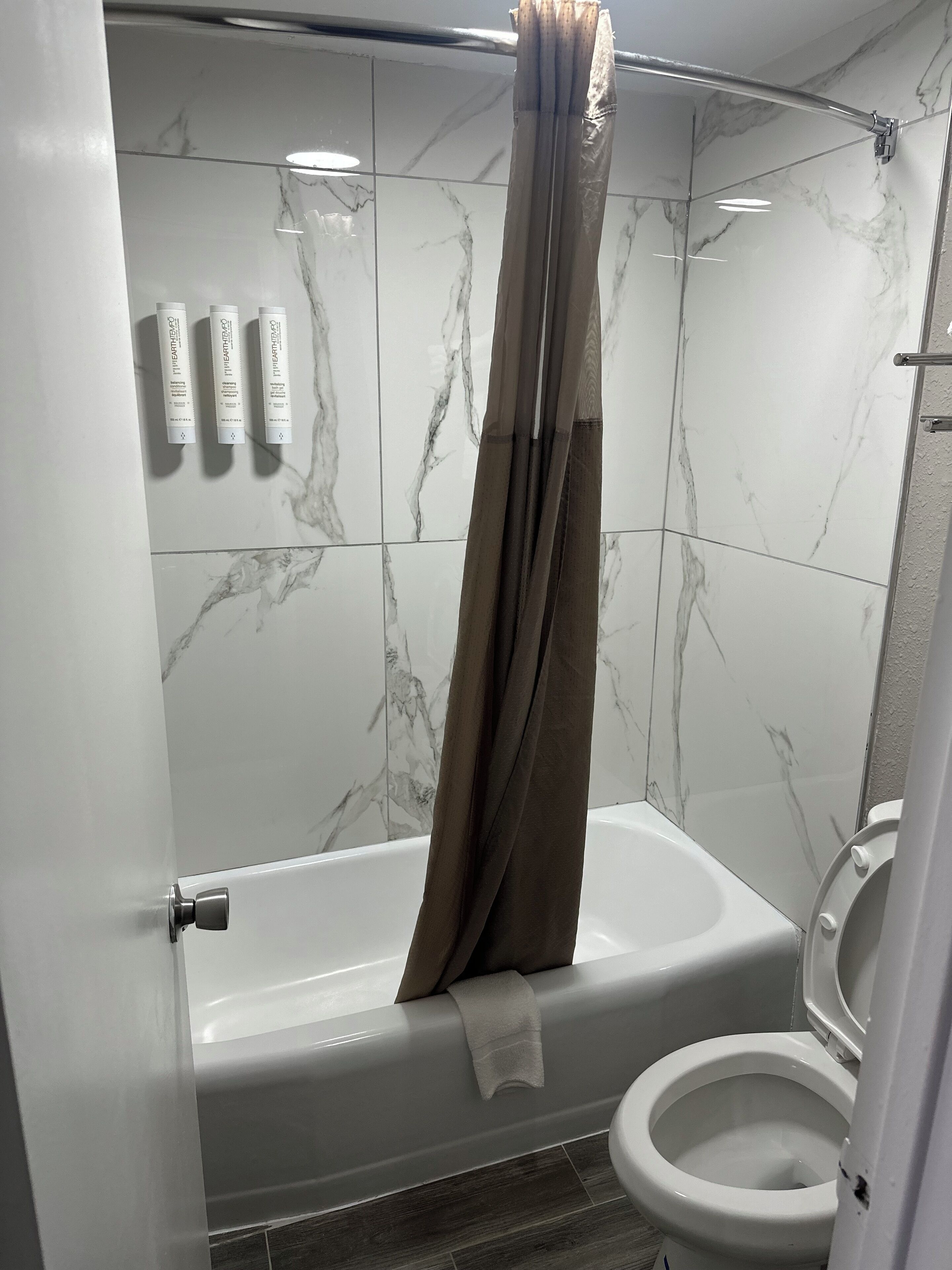 Un baño con bañera, inodoro y cortina de ducha.