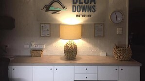 A kitchen counter with a lamp, a clock, and a sign for 'Bega Downs Motor Inn'. - Bega Downs Motor Inn (Bega)