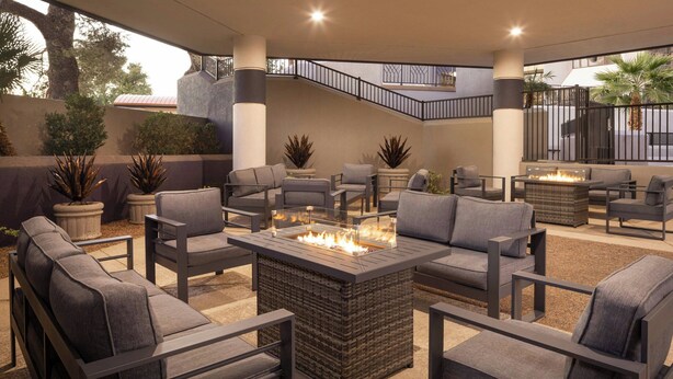 A modern outdoor seating area with sofas and a central fire feature. - Delta Hotels by Marriott Phoenix Mesa (Mesa)