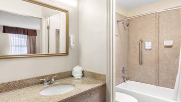Un baño con lavabo, espejo y bañera.