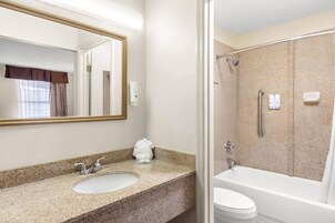 Un baño con lavabo, espejo y bañera.