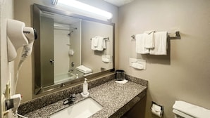 A bathroom with a sink, mirror, towel rack, and hair dryer.