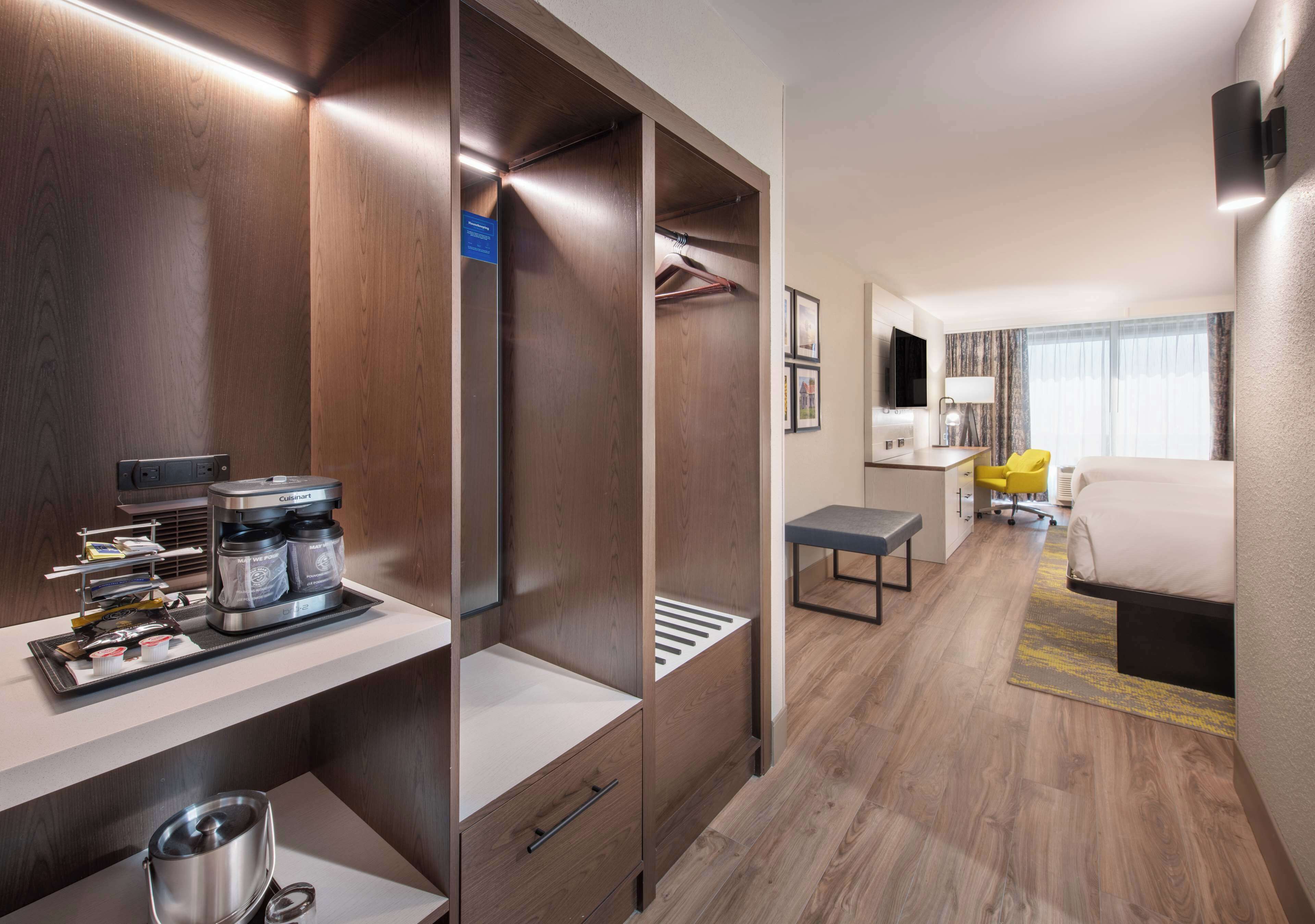 Une chambre d’hôtel équipée d’une kitchenette, d’un lit, d’un bureau et d’une chaise.