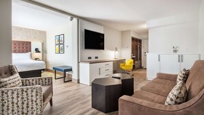 A modern hotel room with a bed, a sofa, a desk, and a TV. - Doubletree by Hilton Monroe Township Cranbury (Monroe Township)