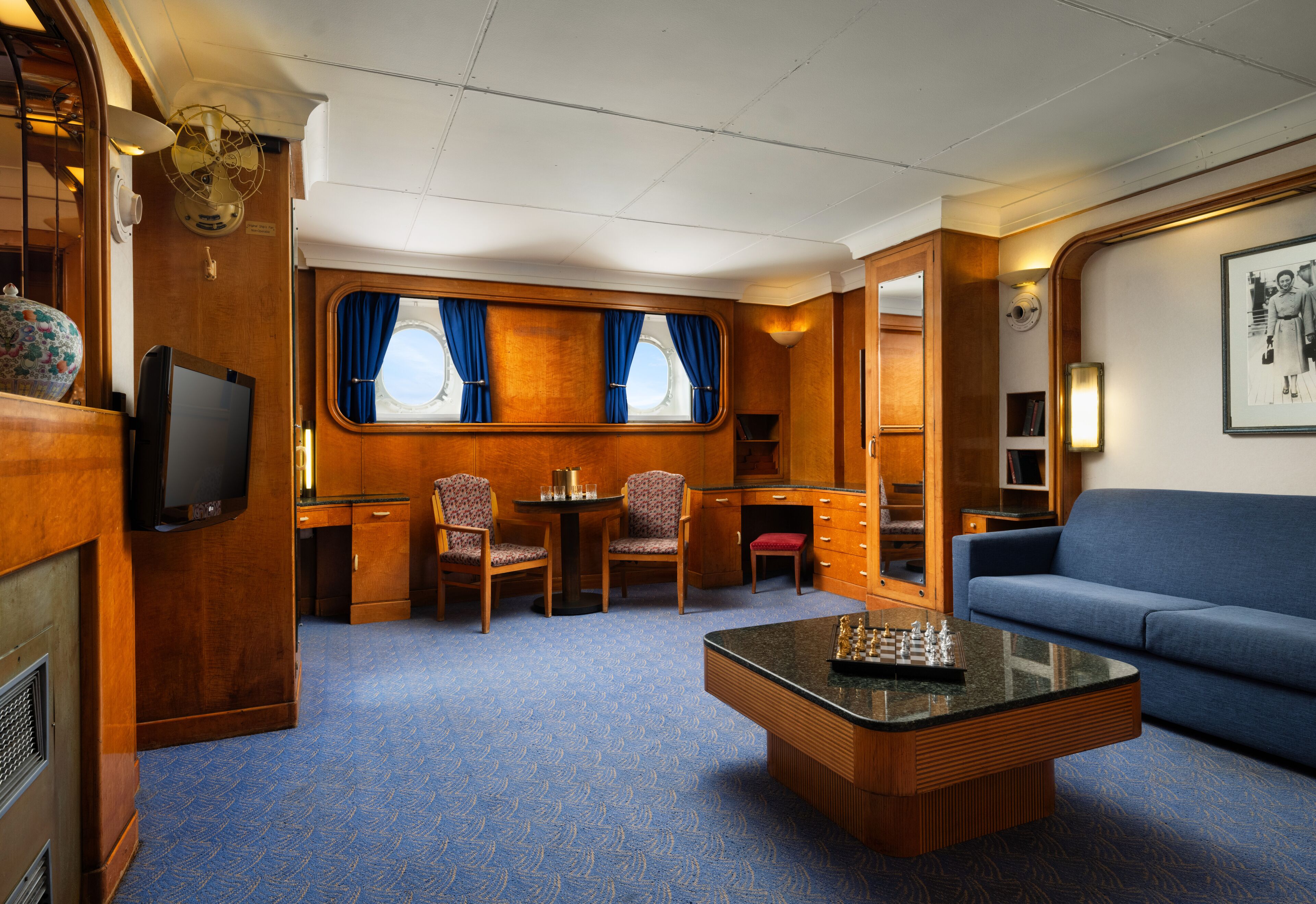 A compact, well-appointed cabin with a television, seating area, and a small table.