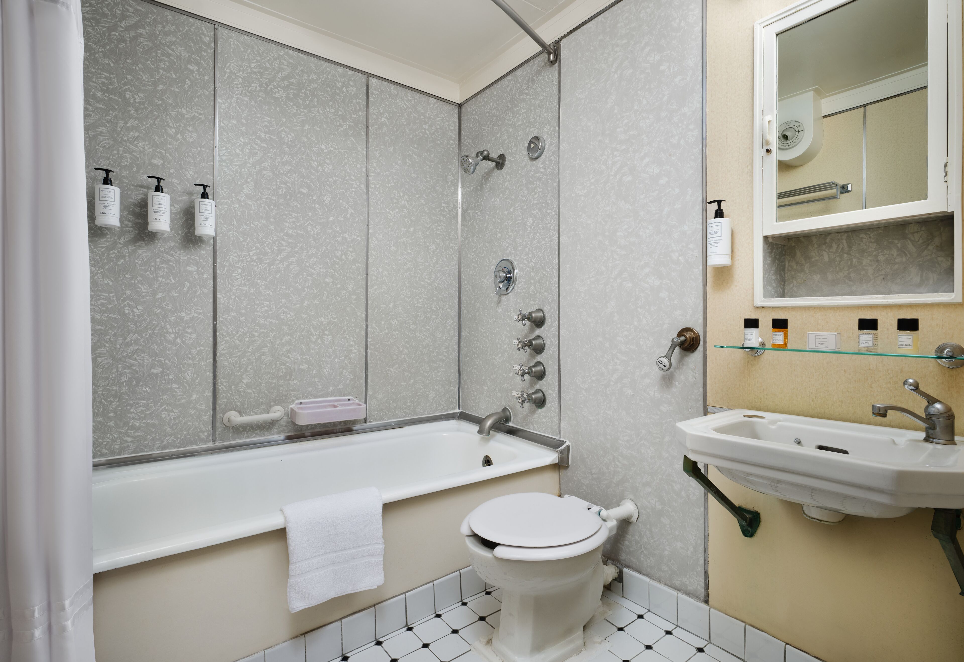 A bathroom with a bathtub, toilet, and sink.