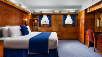 Une chambre avec un grand lit, des murs en bois, un bureau et une chaise.