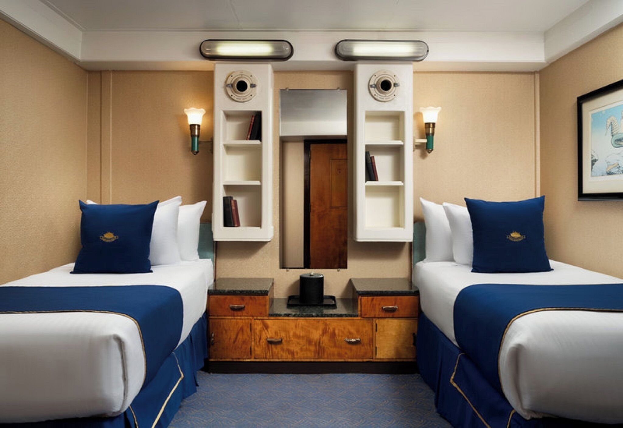 A hotel room with two beds, a wooden dresser, a mirror, and wall-mounted shelves.