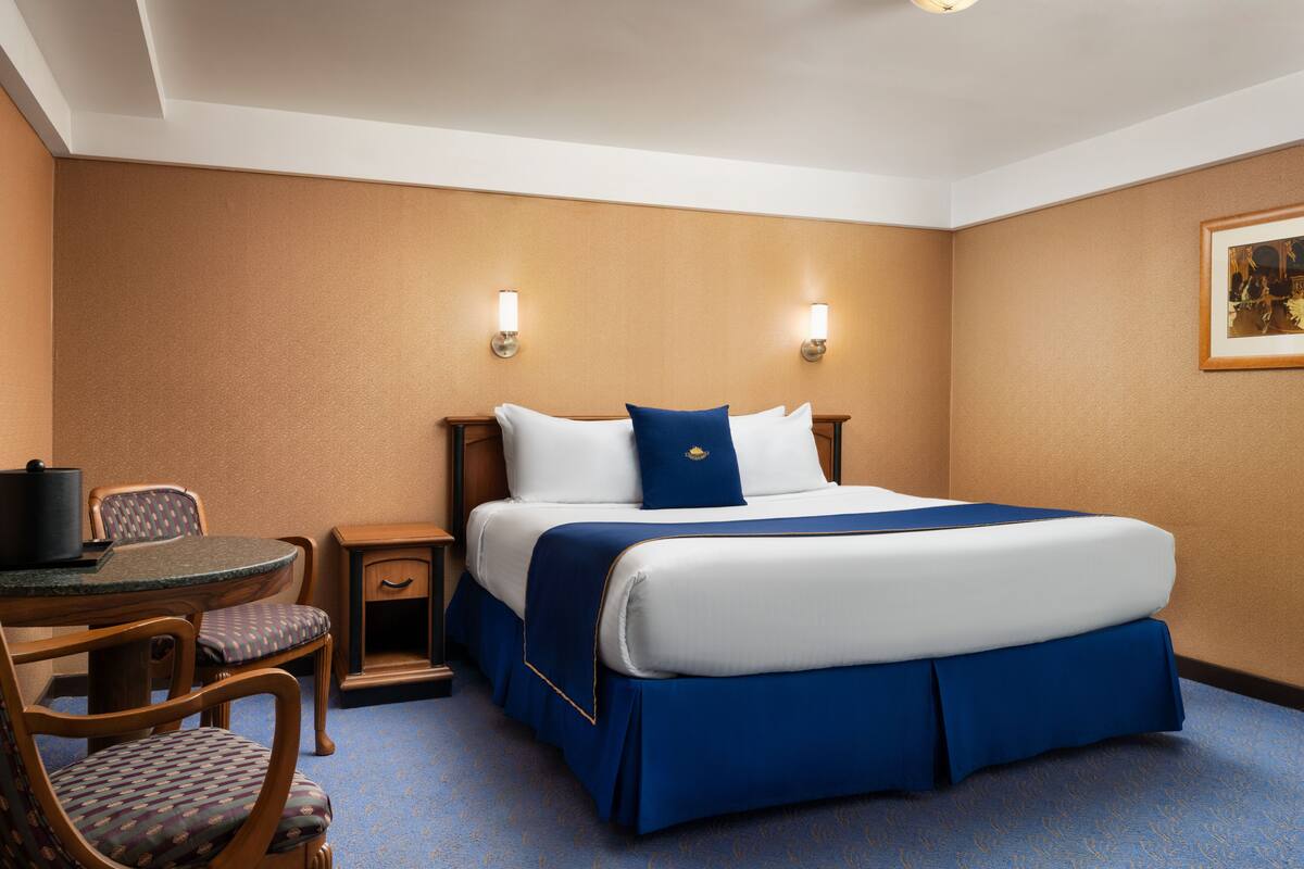 Una habitación de hotel con una cama, un escritorio y dos sillas.