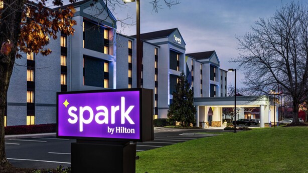 A hotel with a prominent 'spark by Hilton' sign, multiple floors, and a parking lot. - Spark by Hilton Germantown Washington DC North (Germantown)