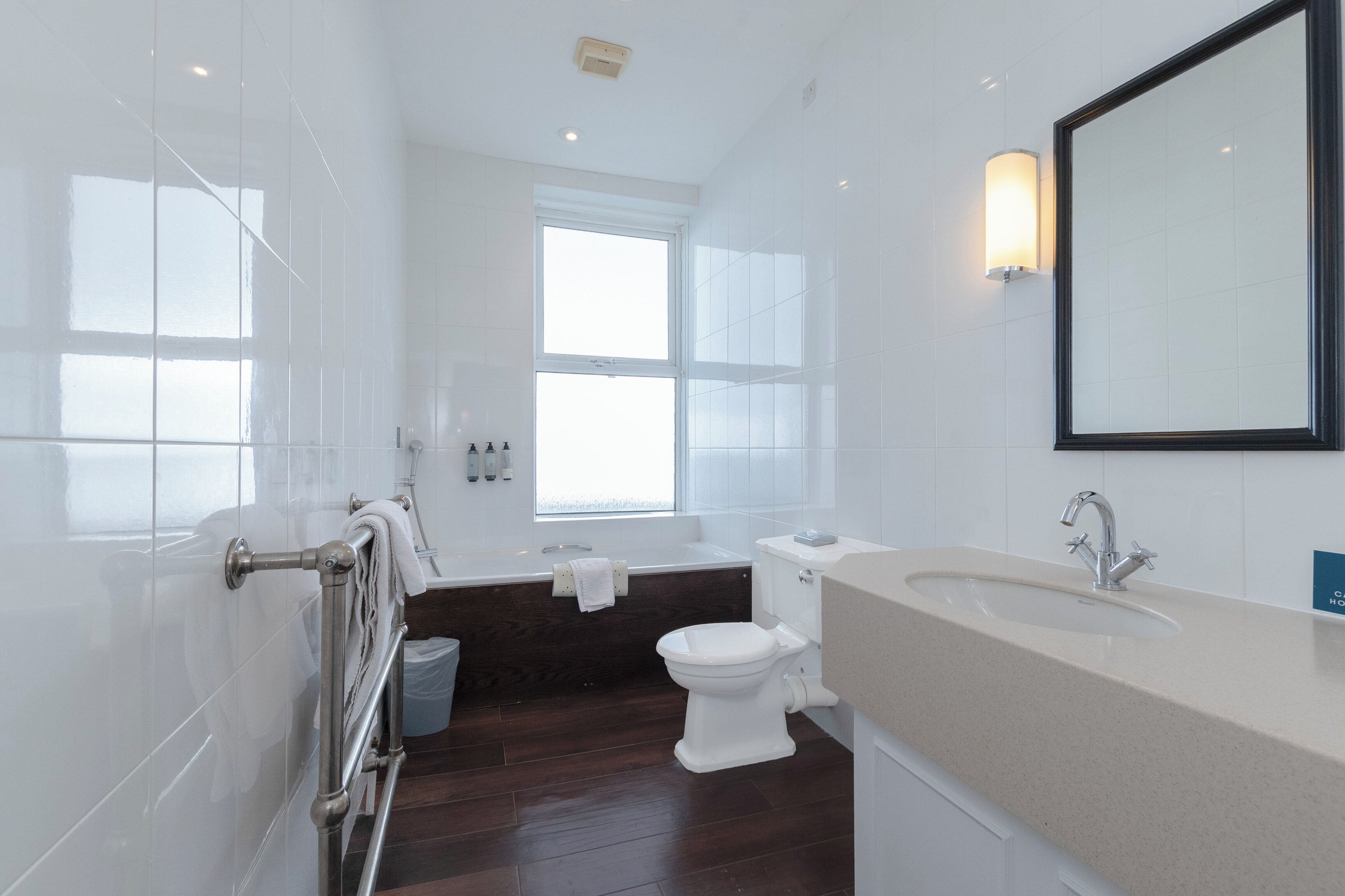 A modern bathroom with a bathtub, toilet, and sink.