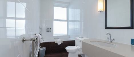 A modern bathroom with a bathtub, toilet, and sink.