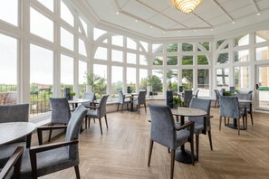A spacious indoor area with large windows, wooden flooring, and modern furniture. - Bournemouth Carlton Hotel by Belvilla (Bournemouth)