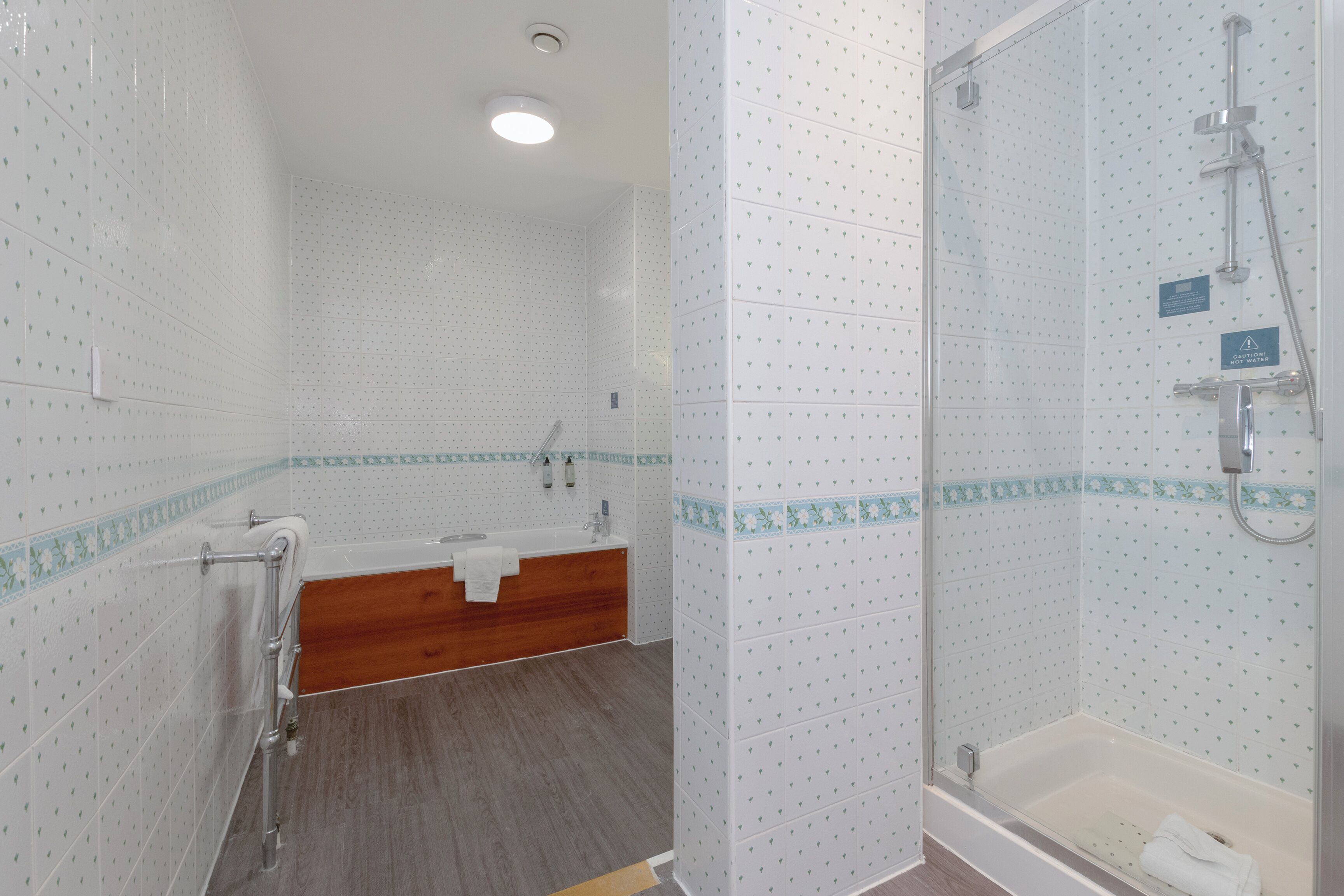 Un baño con ducha, bañera y tocador de madera.