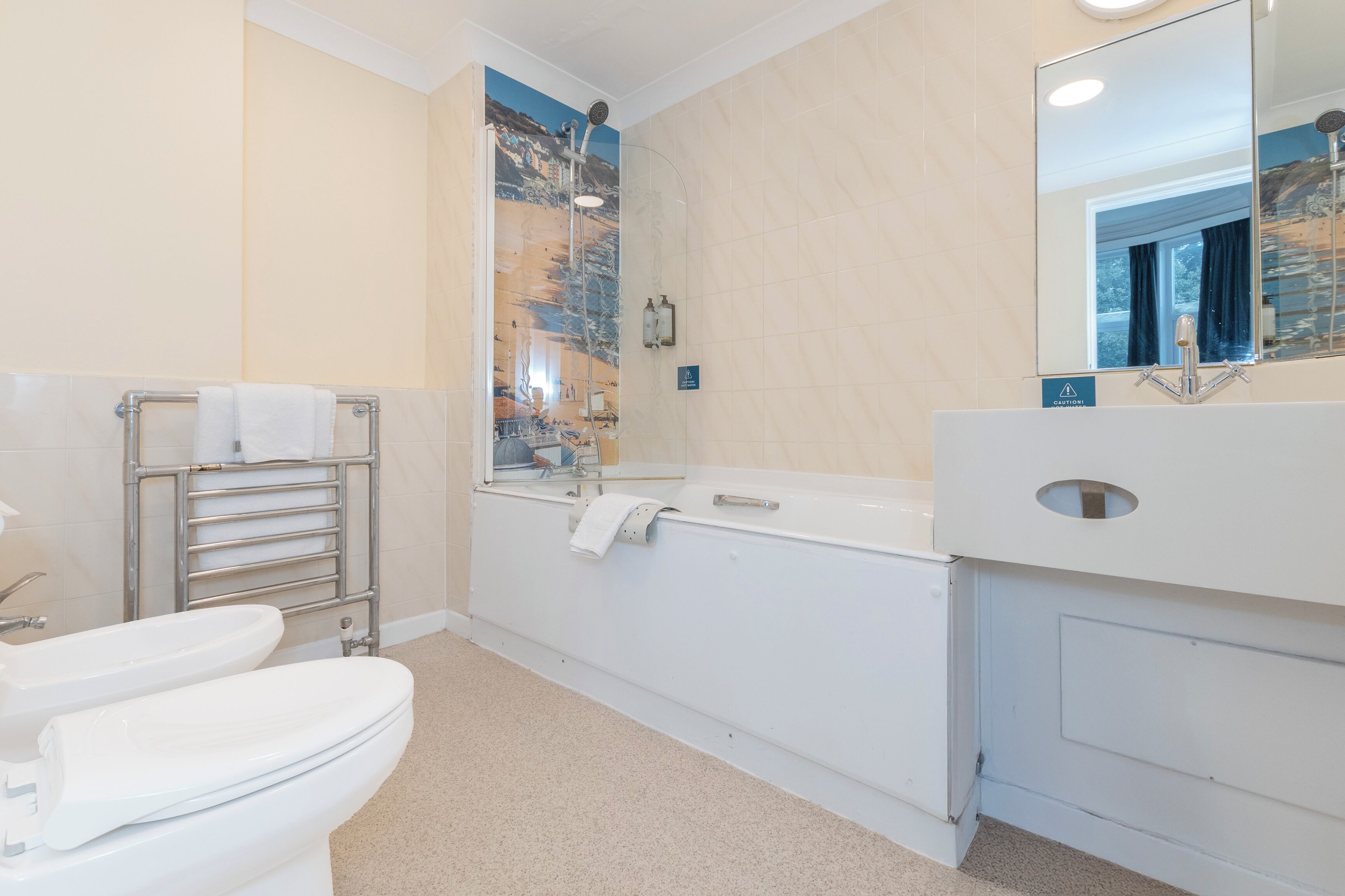 A bathroom with a toilet, bidet, and bathtub.