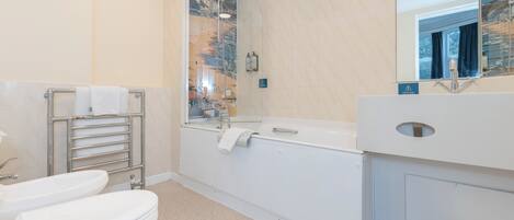 A bathroom with a toilet, bidet, and bathtub.