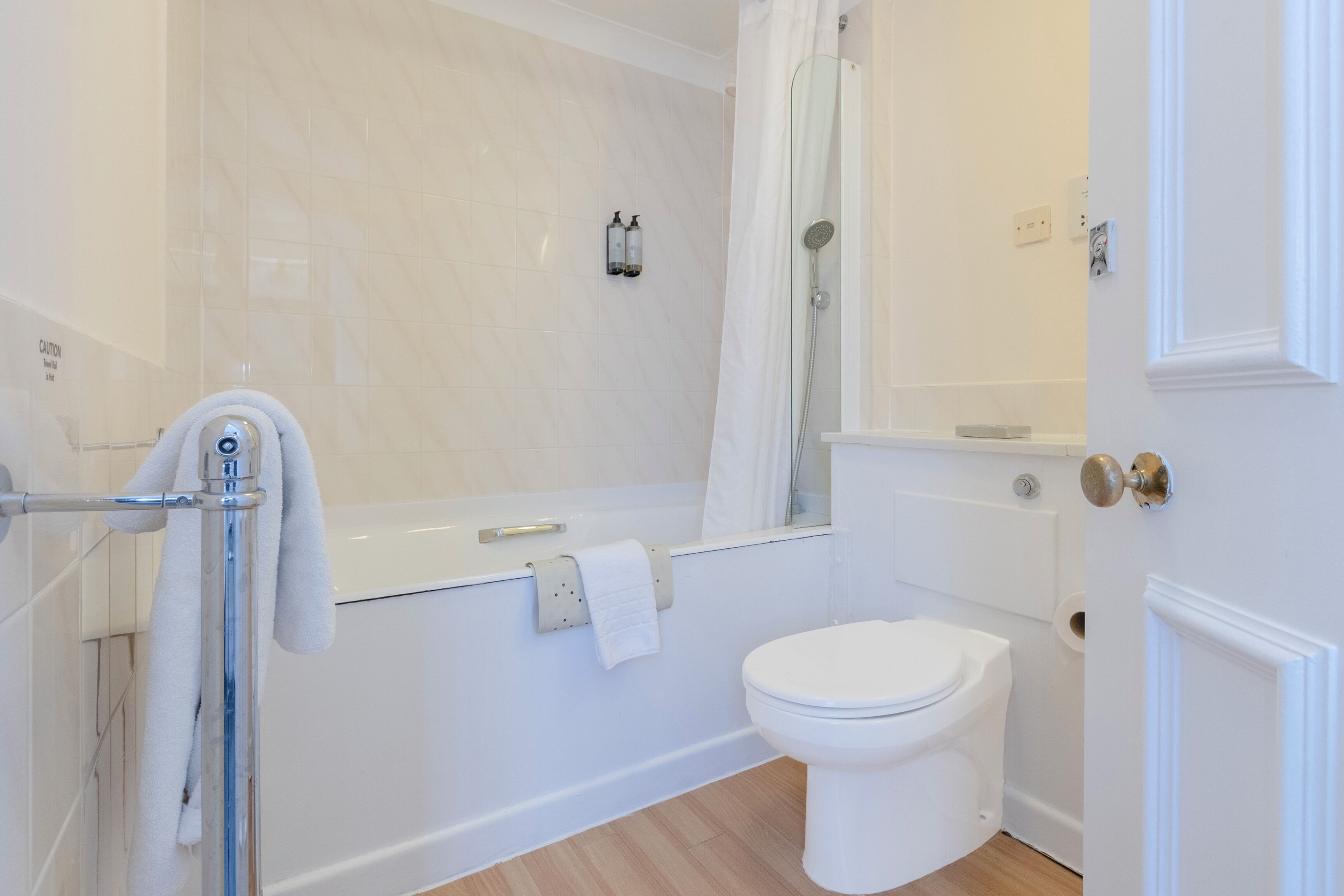 Een badkamer met een badkuip, toilet en douche.