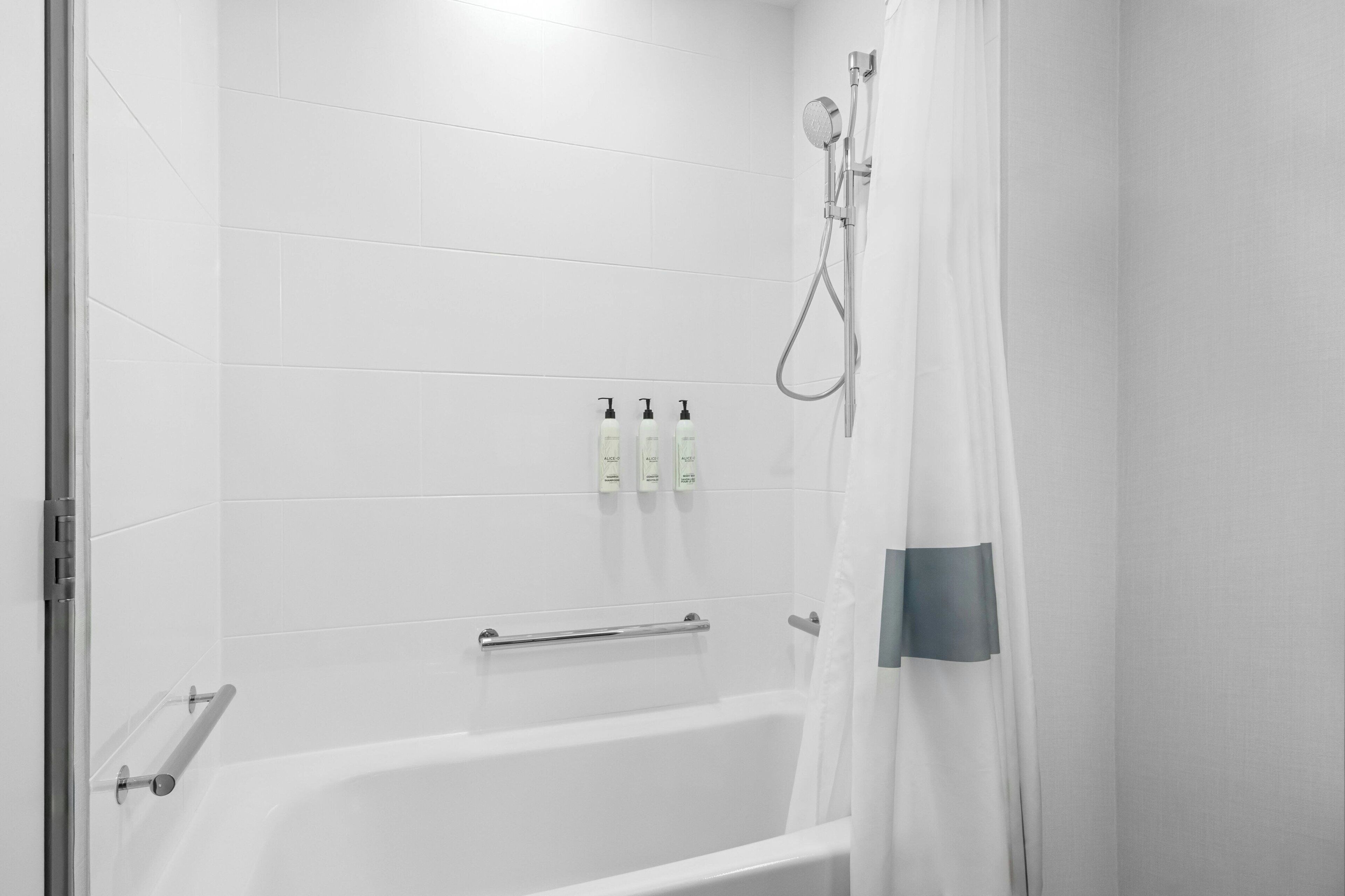 A bathroom with a bathtub, a shower, and a towel rack.