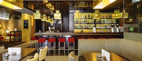 A bar area with a counter, stools, and a seating area with tables and chairs.