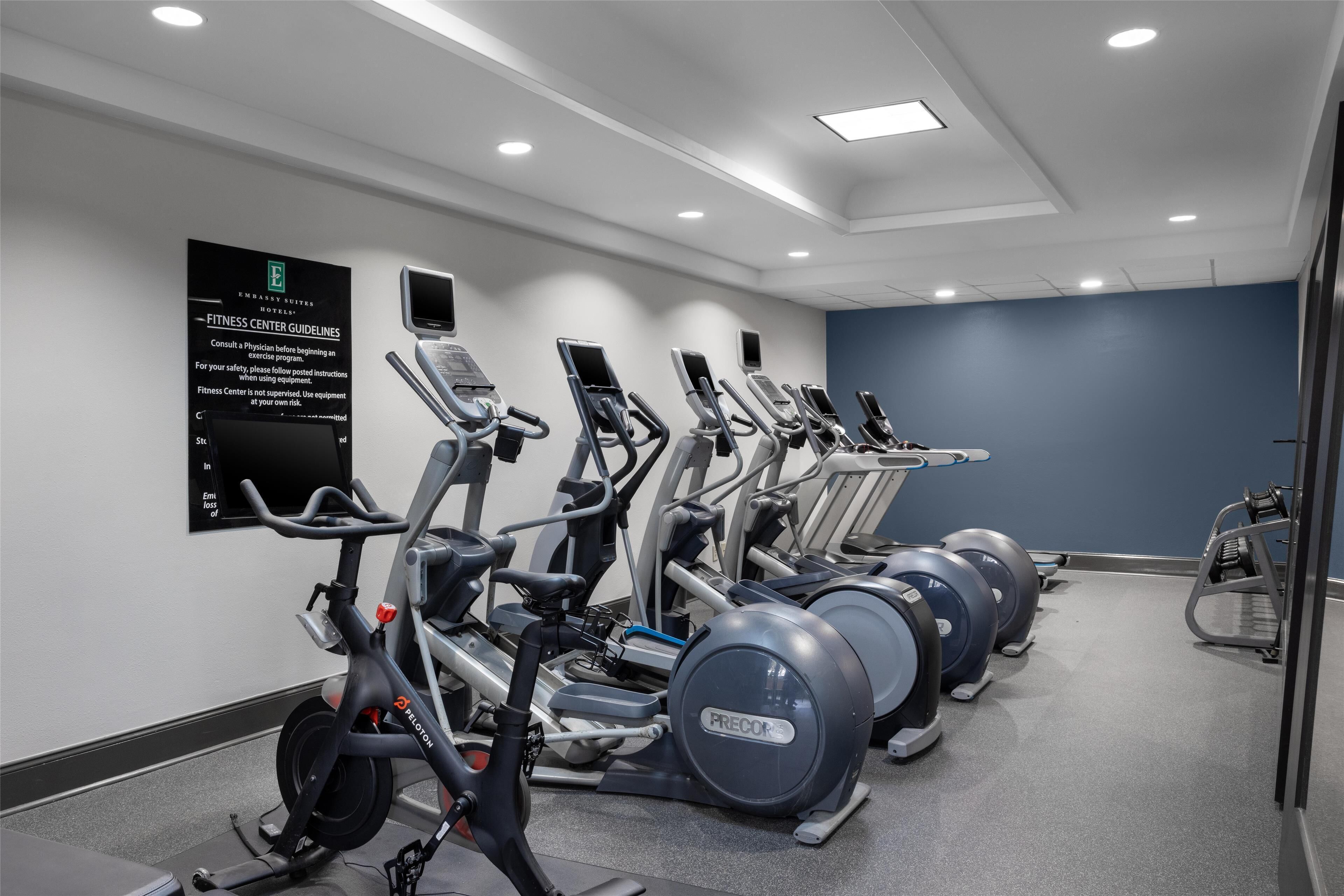 A fitness center with treadmills, elliptical machines, and stationary bikes.