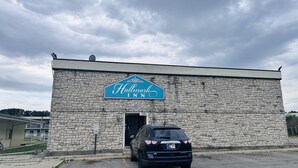 A stone building with a sign for 'Hallmark Inn' and a Chevrolet car parked in front. - Hallmark Inn By OYO Fort Wayne (Fort Wayne)