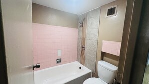 A bathroom with a bathtub, toilet, and shower. - Hallmark Inn By OYO Fort Wayne (Fort Wayne)