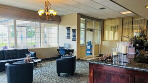 A hotel lobby with a reception desk, seating area, and large windows. - FairBridge Extended Stay – a Kitchenette Hotel (Idaho Falls)