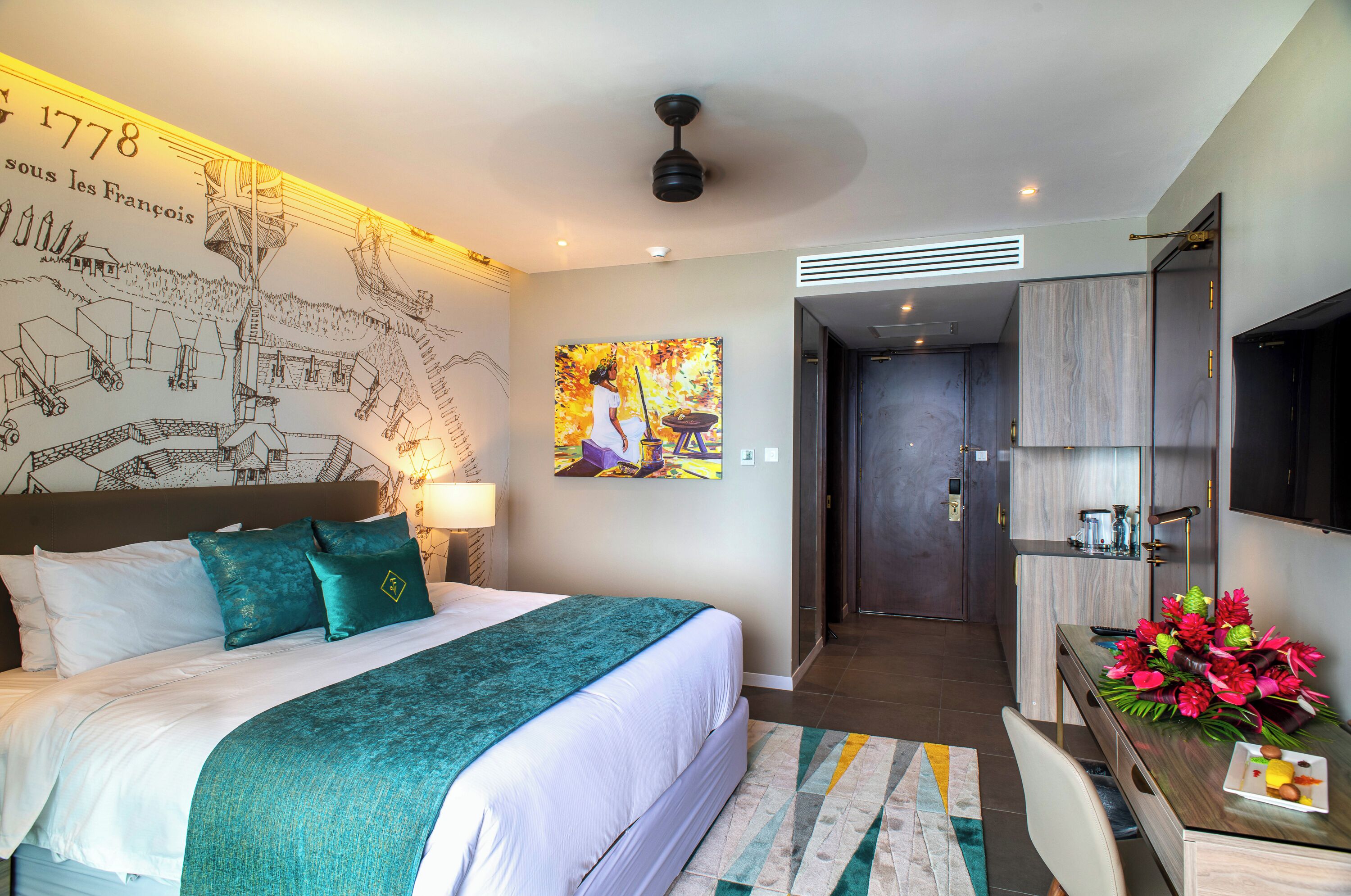 Een hotelkamer met een groot bed, een bureau met een bloevas, een schilderij aan de muur en een kaart van Frankrijk.
