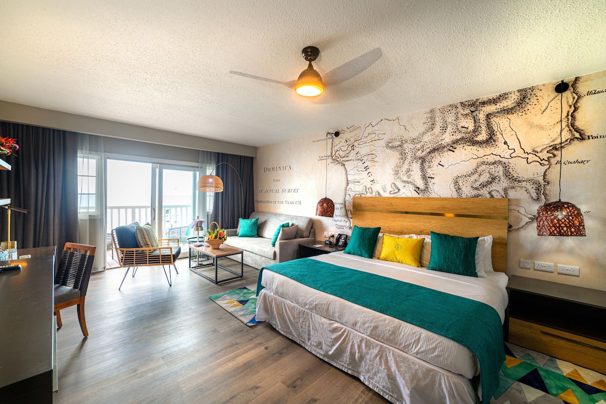 Ein modernes Hotelzimmer mit einem großen Bett, einer Couch, einem Schreibtisch und einer Karte an der Wand.
