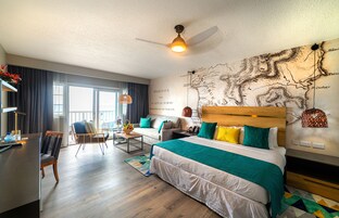 Una habitación de hotel moderna con una cama grande, un sofá, un escritorio y un mapa en la pared.
