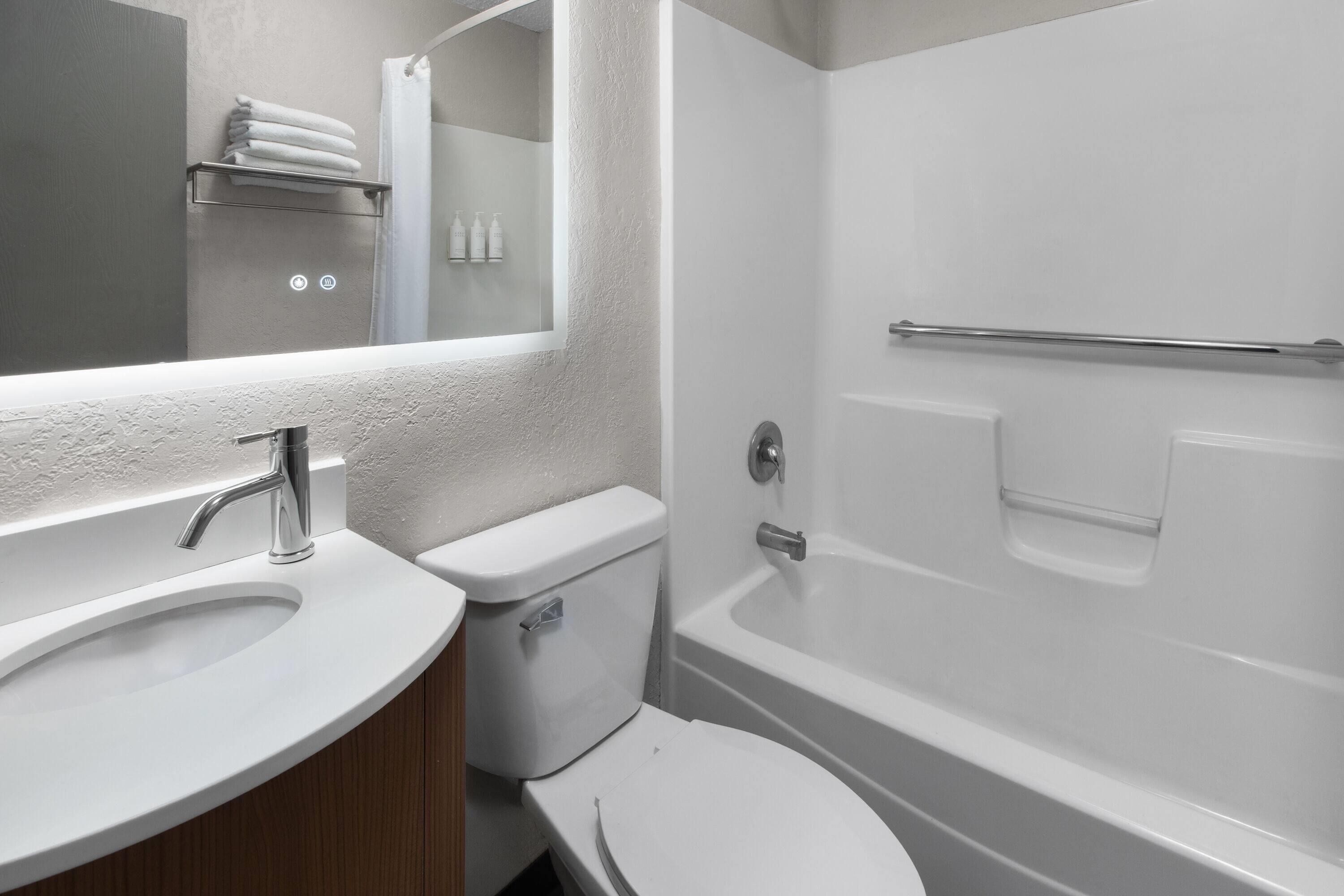 A bathroom with a sink, toilet, and bathtub.
