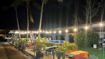 Enjoy al fresco dining under the stars in our serene outdoor space, surrounded by lush greenery and a tranquil pool.