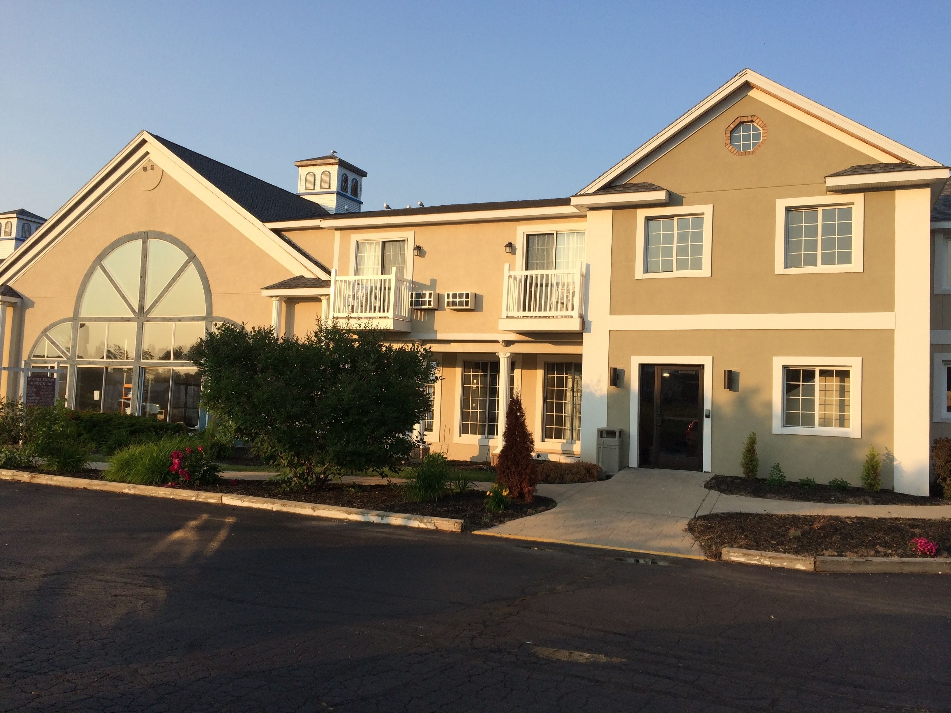 A two-story house with a large bay window, a balcony, and a garage.